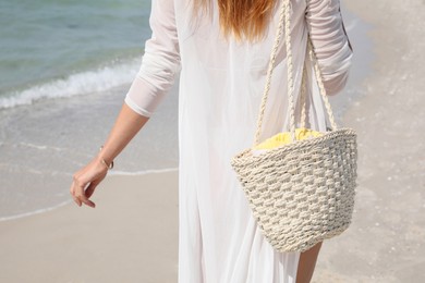 Photo of Woman with beach bag walking near sea, closeup