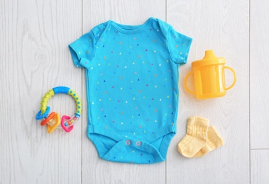 Photo of Flat lay composition with fashionable children's clothes on wooden background