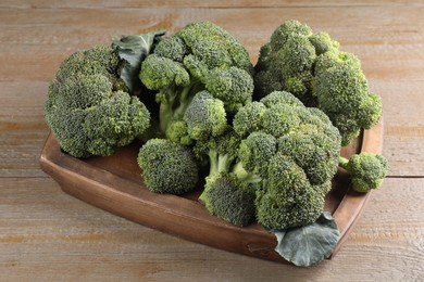 Photo of Tray with fresh raw broccoli on wooden table