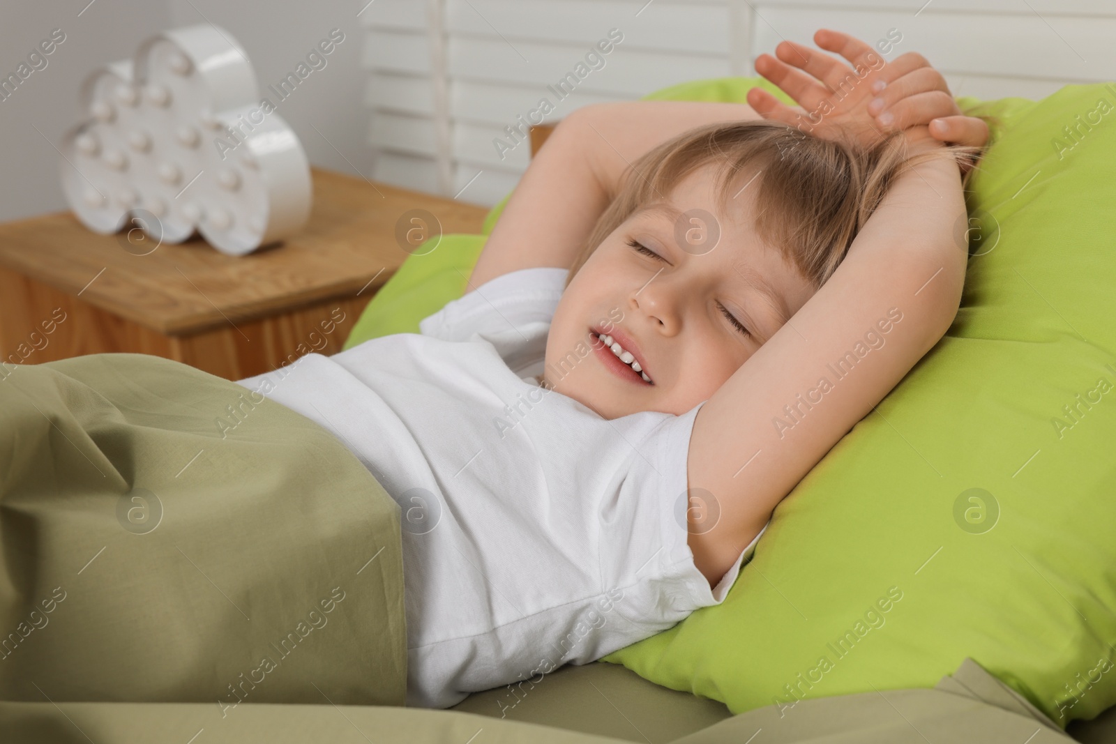 Photo of Little boy snoring while sleeping in bed indoors