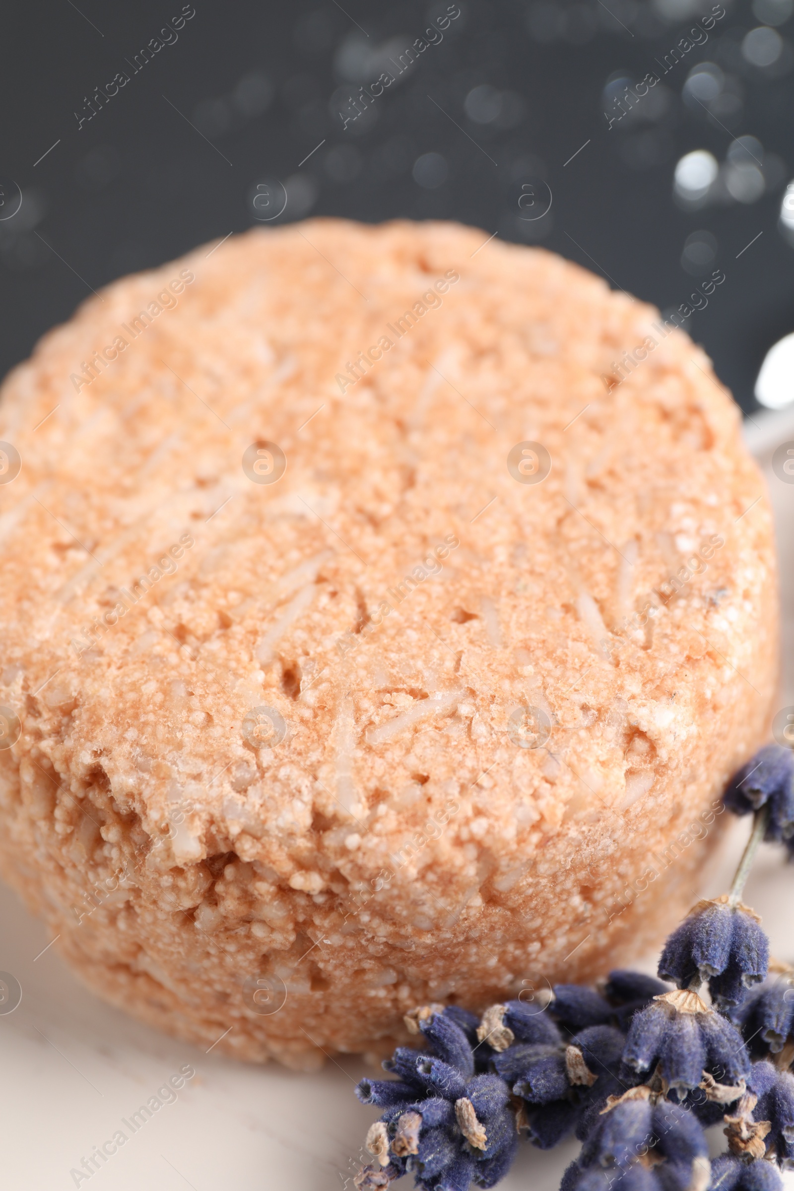 Photo of Solid shampoo bar and lavender flowers on white table, closeup