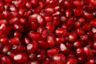 Many tasty pomegranate seeds as background, closeup