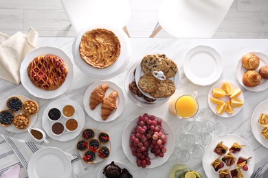 Photo of Variety of snacks on white marble table in buffet style indoors, flat lay