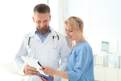 Photo of Doctor and medical assistant working in clinic. Health care service