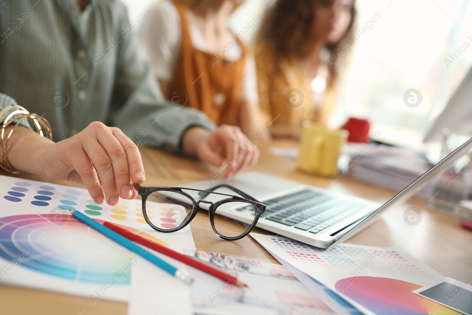 Photo of Female designer working with laptop at table, closeup