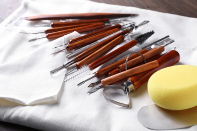 Set of different clay crafting tools on wooden table, closeup