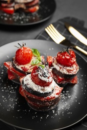Photo of Baked eggplant with tomatoes, cheese and basil on black table, closeup