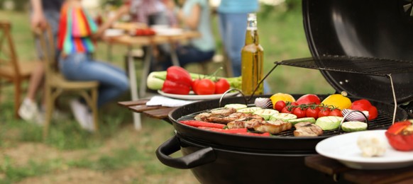 Image of Modern grill with meat and vegetables outdoors, closeup. Banner design