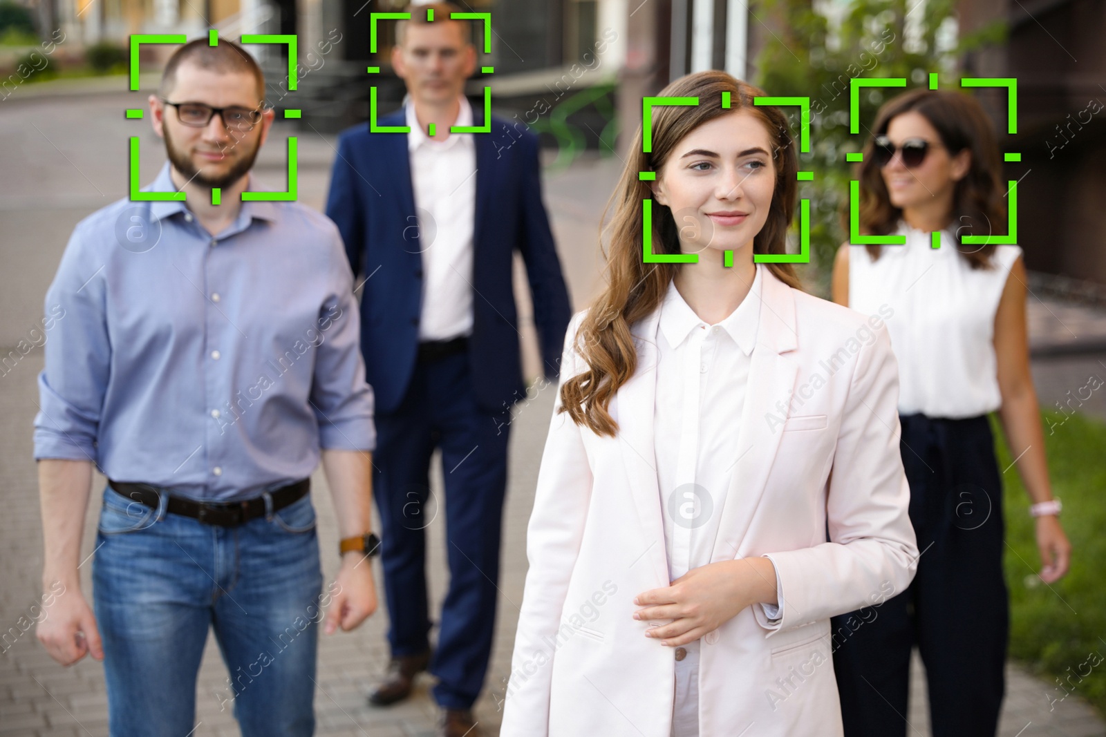 Image of Facial recognition system identifying people on city street 