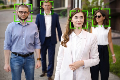 Image of Facial recognition system identifying people on city street 