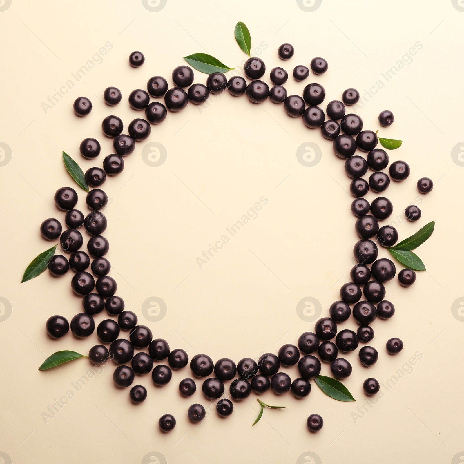 Photo of Frame made of fresh acai berries on beige background, flat lay. Space for text