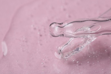 Pipettes with cosmetic serum on pink background, closeup. Space for text