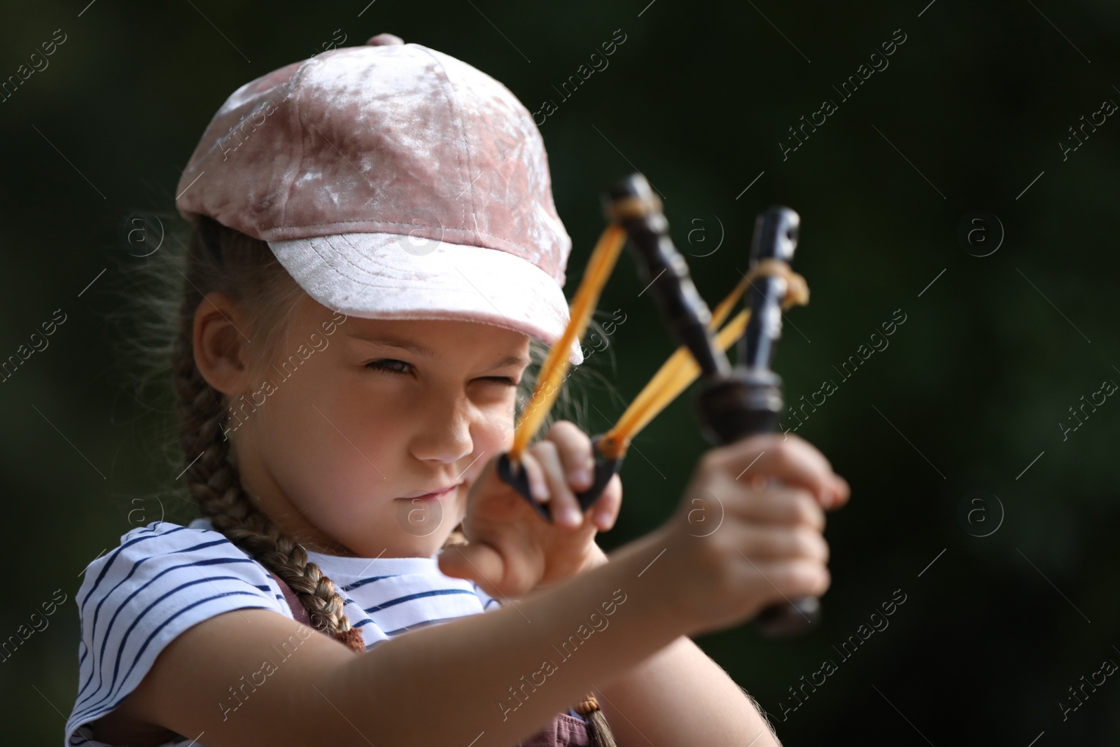 Photo of Little girl playing with slingshot in park