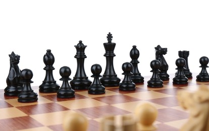 Set of black chess pieces on wooden board against white background