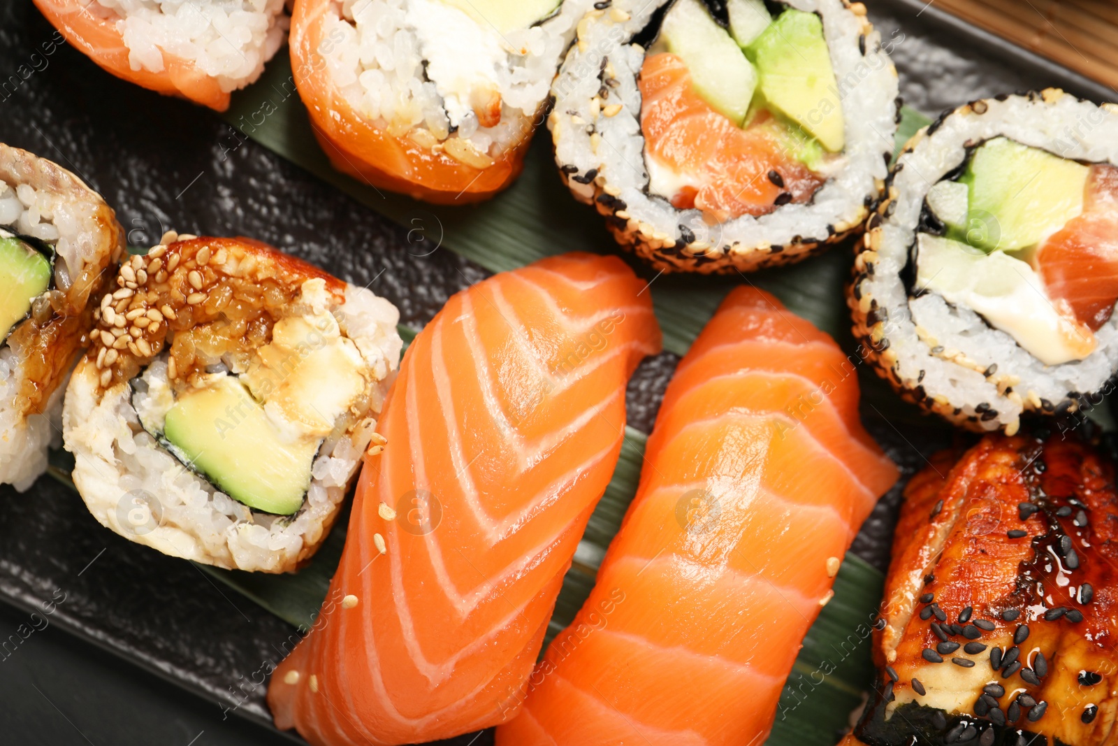 Photo of Set of delicious sushi rolls on board, top view