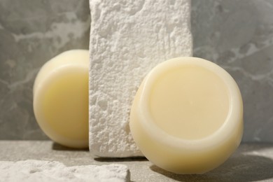 Photo of Solid shampoo bars on grey marble background, closeup. Hair care