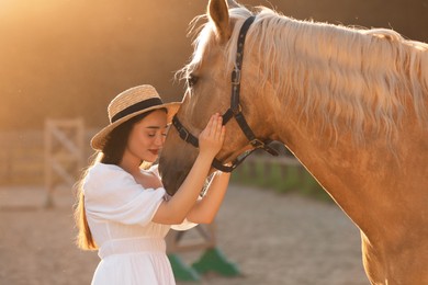 Photo of Woman with adorable horse outdoors on sunny day. Lovely domesticated pet