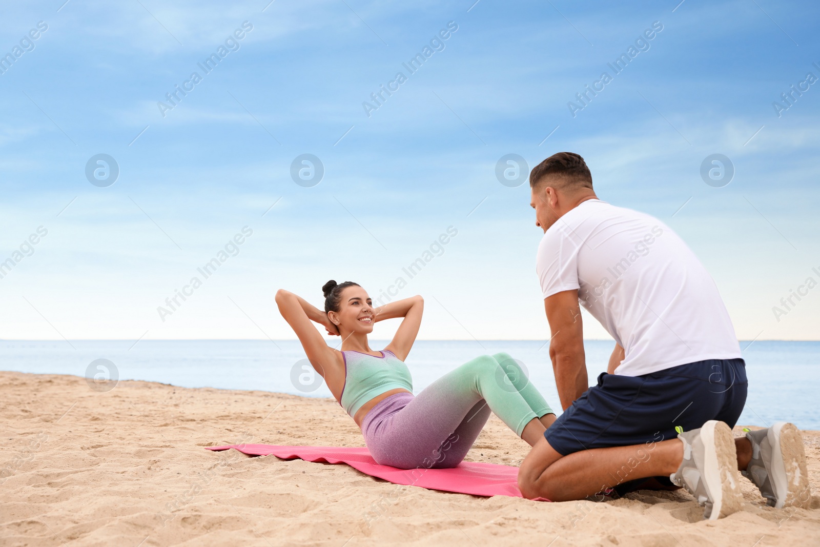 Photo of Couple doing exercise together on beach, space for text. Body training