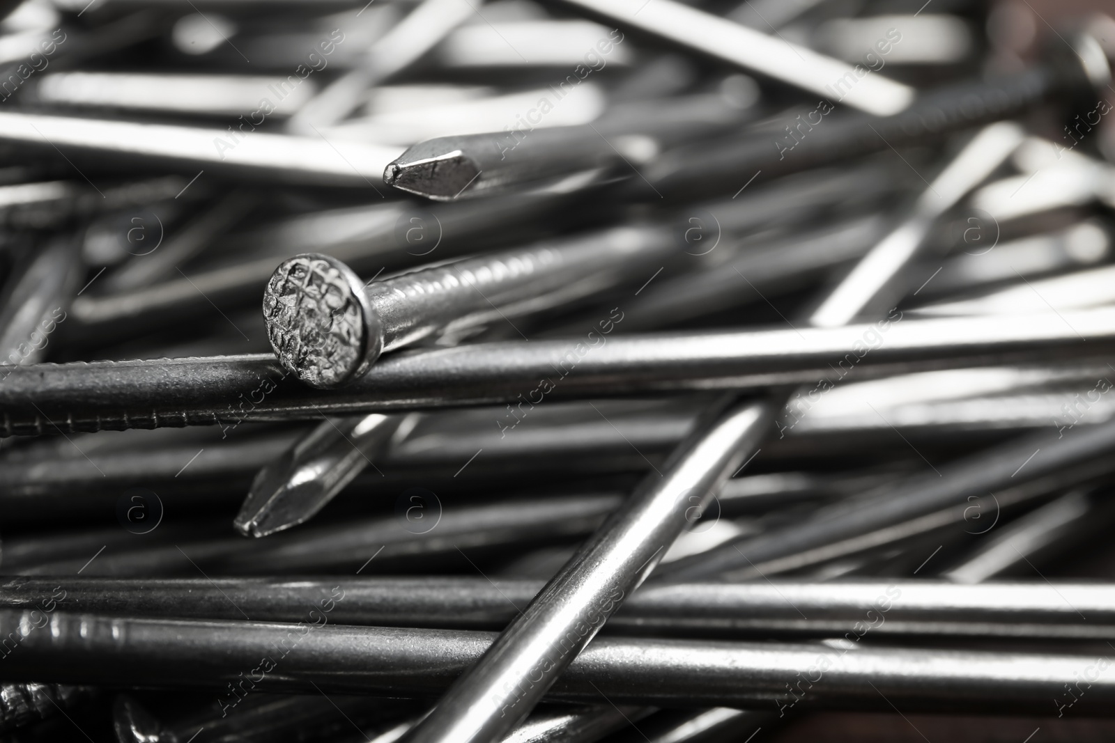 Photo of Pile of metal nails as background, closeup