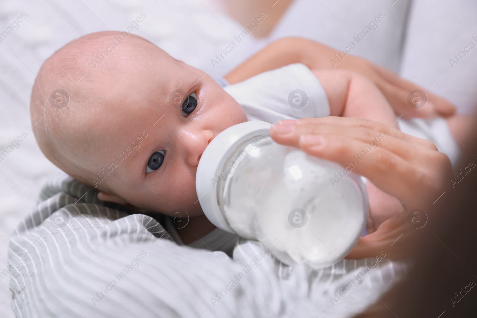 Photo of Mother feeding her little baby from bottle, closeup