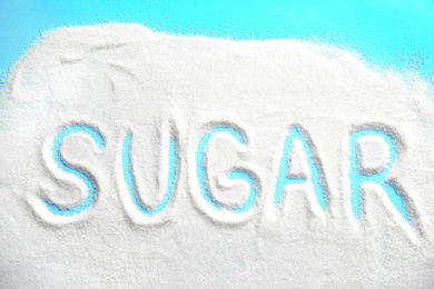 Word SUGAR written on sugar sand