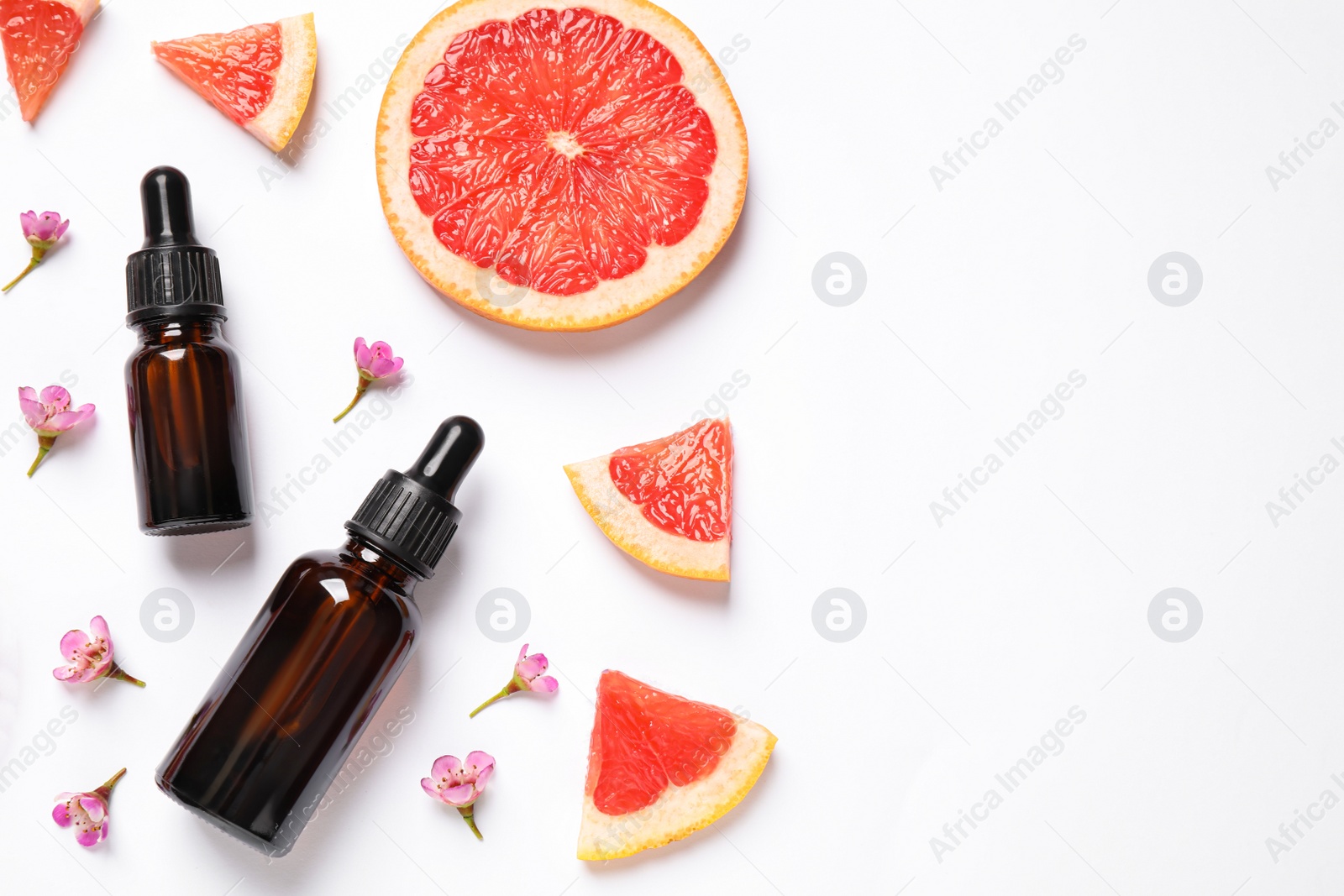 Photo of Flat lay composition with bottles of citrus essential oil on white background. Space for text