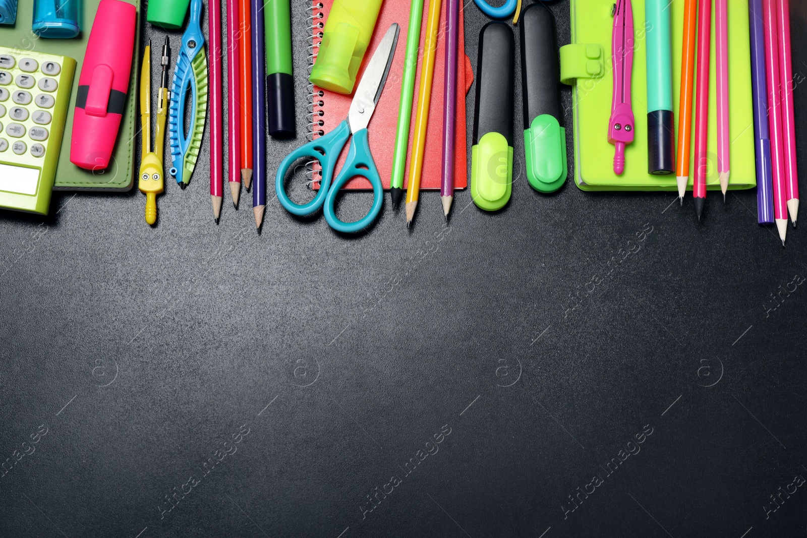 Photo of Flat lay composition with school stationery on black chalkboard, space for text