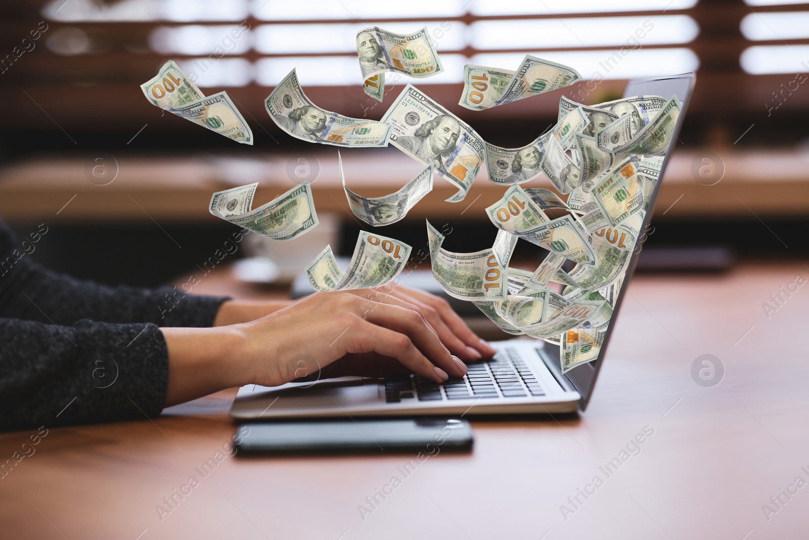 Image of Woman with modern laptop and flying dollar banknotes at table, closeup. People make money online