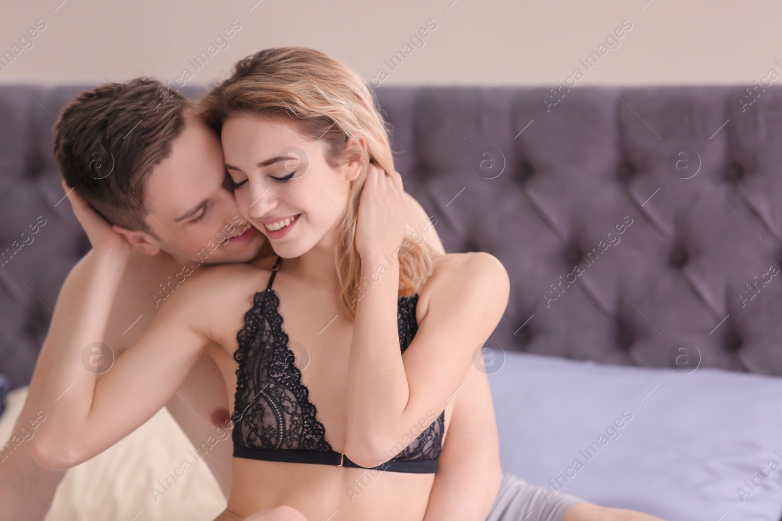 Photo of Sexy young couple being intimate on bed at home