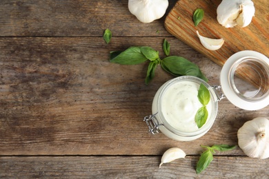 Photo of Flat lay composition with garlic sauce on wooden background. Space for text