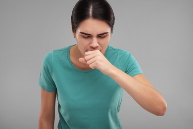 Photo of Woman coughing on grey background. Cold symptoms