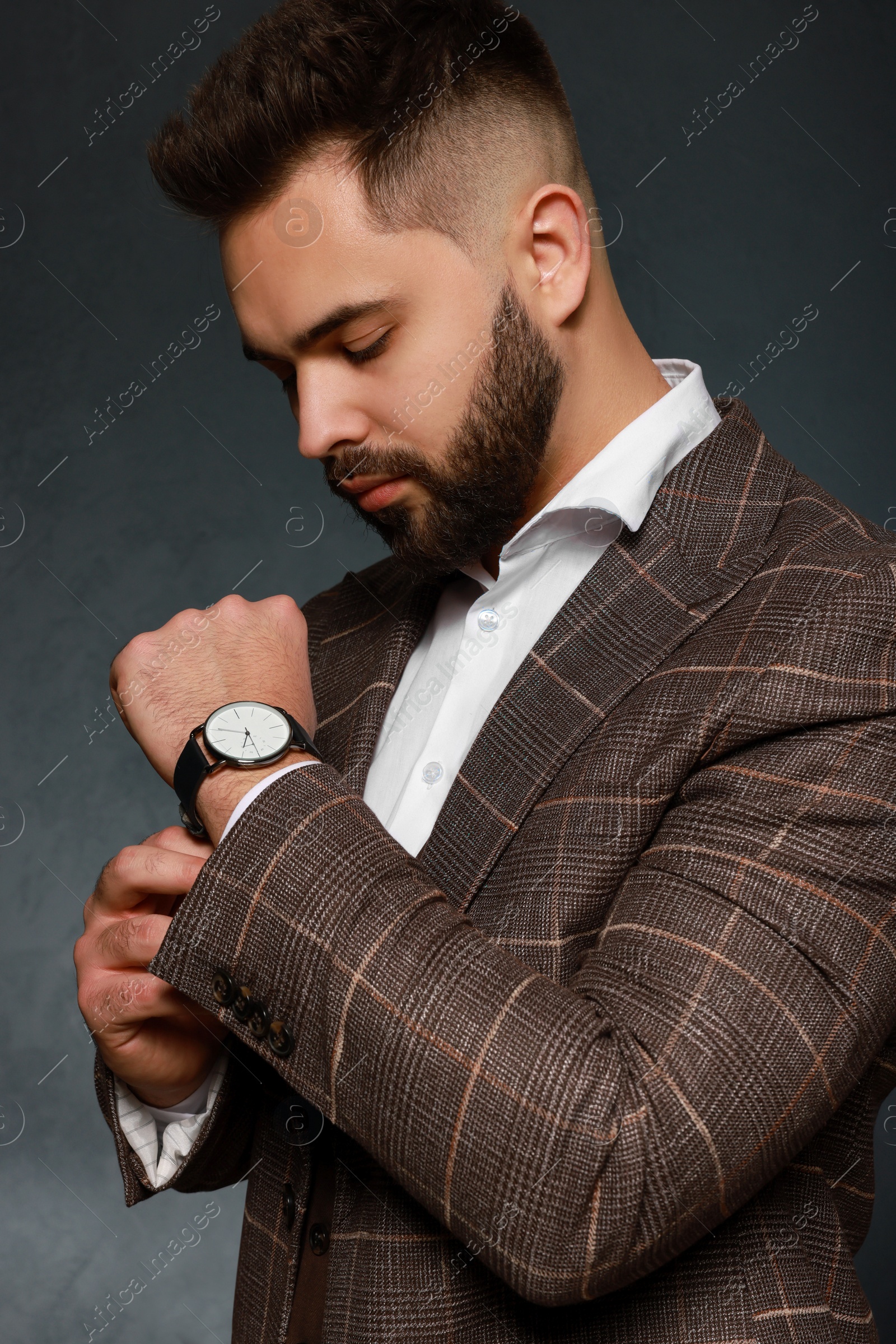 Photo of Handsome bearded man in stylish suit on dark background