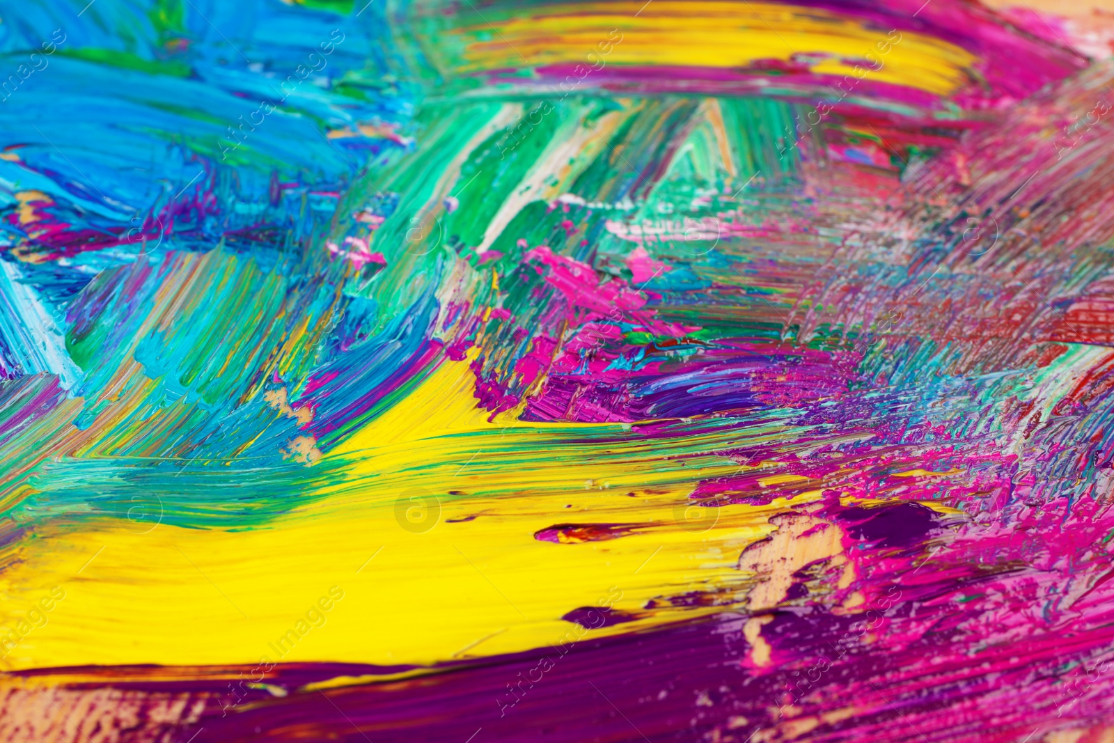 Photo of Closeup view of artist's palette with mixed bright paints as background