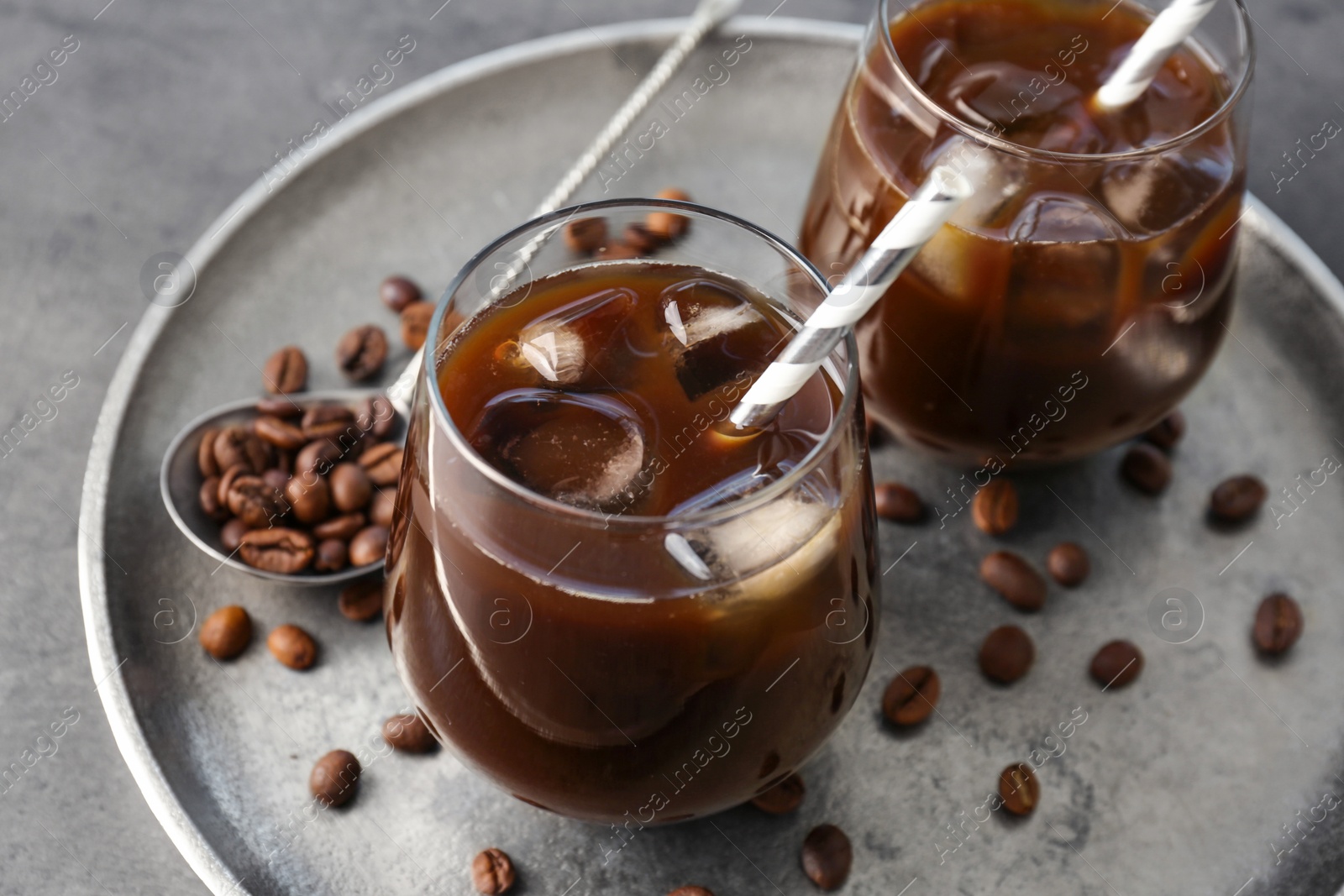 Photo of Glasses with cold brew coffee and beans on tray