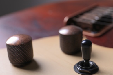 Photo of Closeup view of electric guitar, focus on volume controls