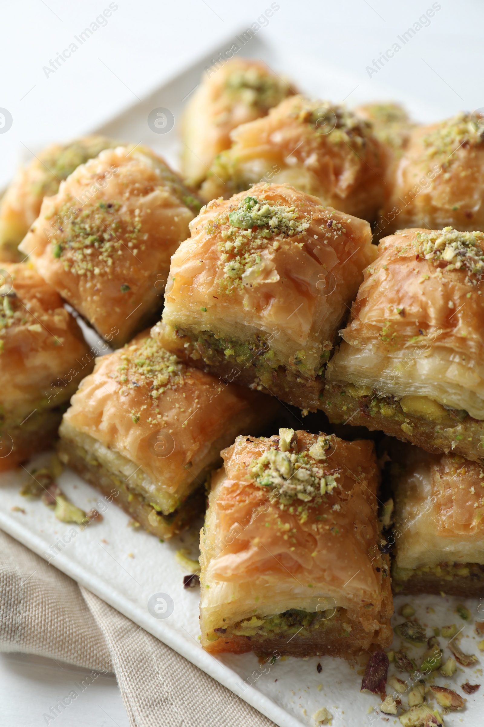 Photo of Delicious fresh baklava with chopped nuts on table, closeup. Eastern sweets