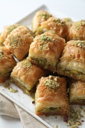 Photo of Delicious fresh baklava with chopped nuts on table, closeup. Eastern sweets