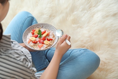 Photo of Woman eating delicious oatmeal with fruits at home. Healthy diet