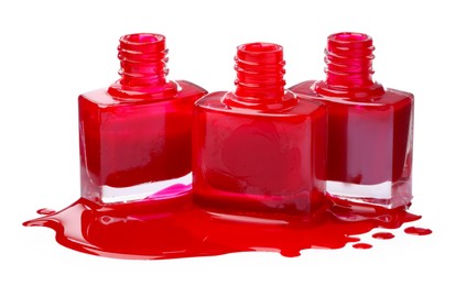Photo of Puddle of red nail polish and bottles isolated on white