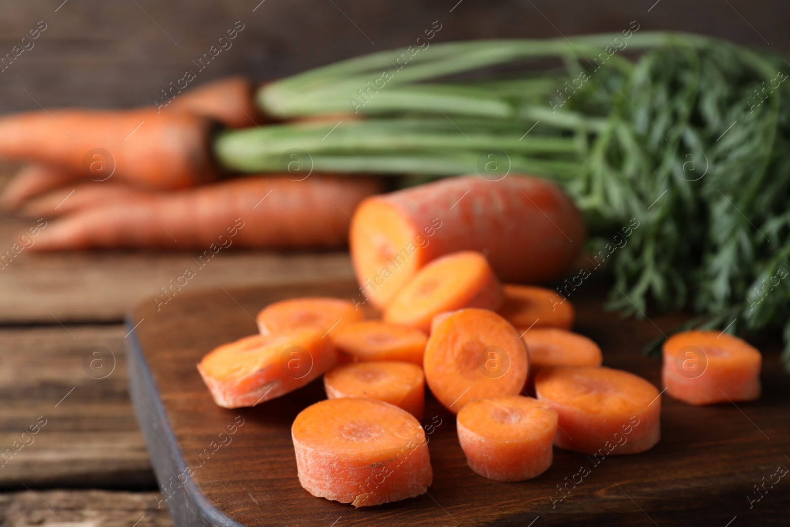 Photo of Fresh cut carrot on wooden table, closeup