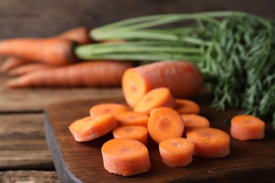 Photo of Fresh cut carrot on wooden table, closeup
