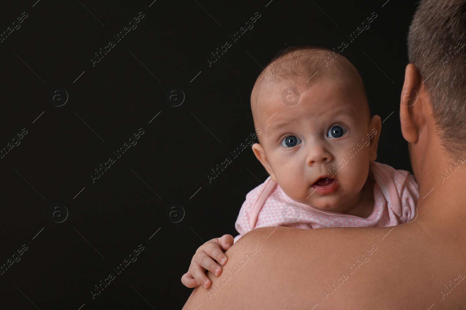 Photo of Father with his little baby on black background. Space for text