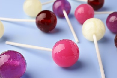 Tasty lollipops on light blue background, closeup