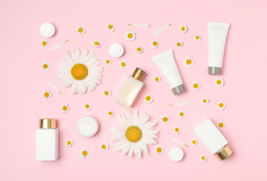 Photo of Flat lay composition with chamomiles and cosmetic products on pink background