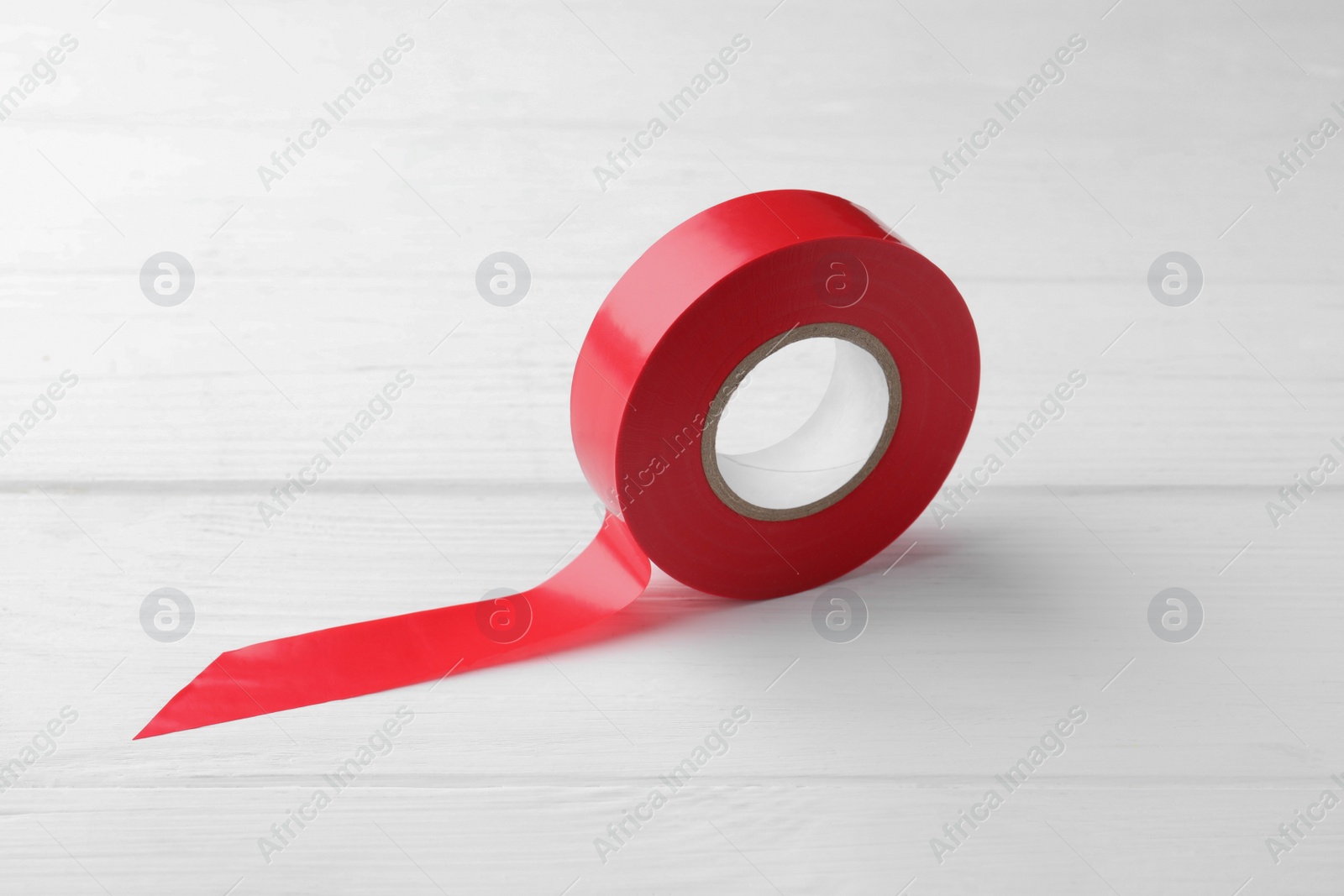 Photo of Red insulating tape on white wooden table