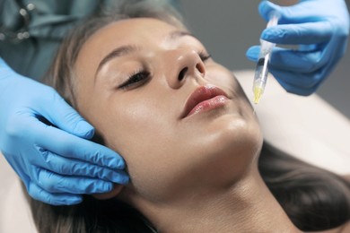 Photo of Beautiful woman getting facial injection in salon, closeup