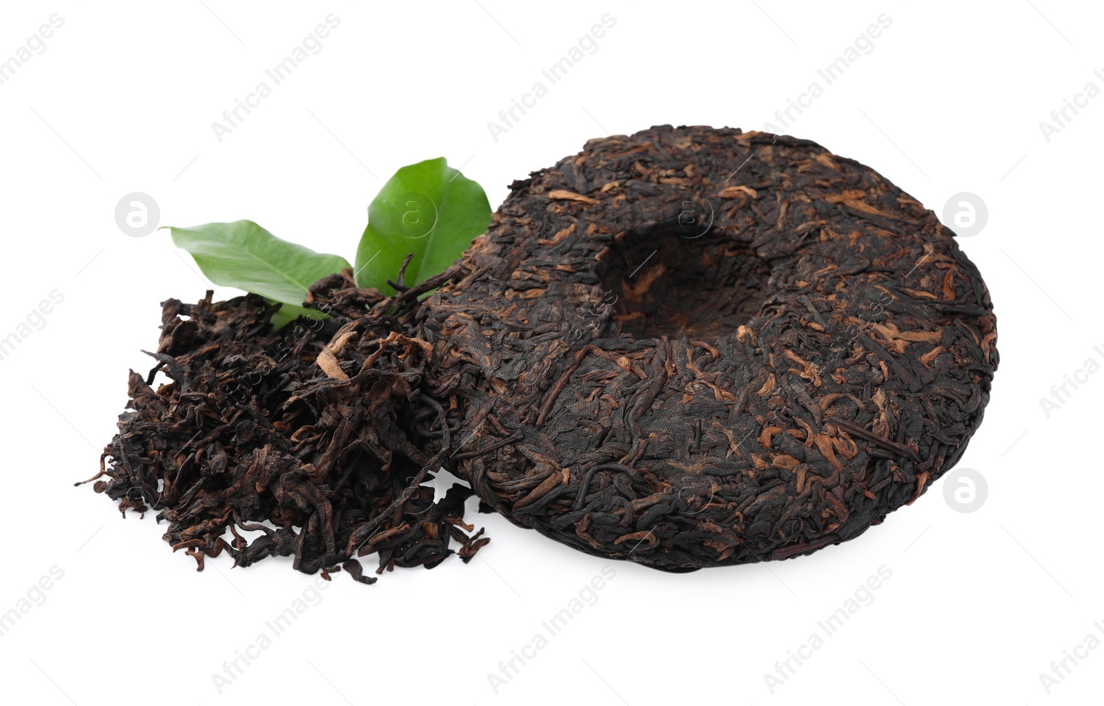 Photo of Broken disc shaped traditional Chinese pu-erh tea and fresh leaves isolated on white