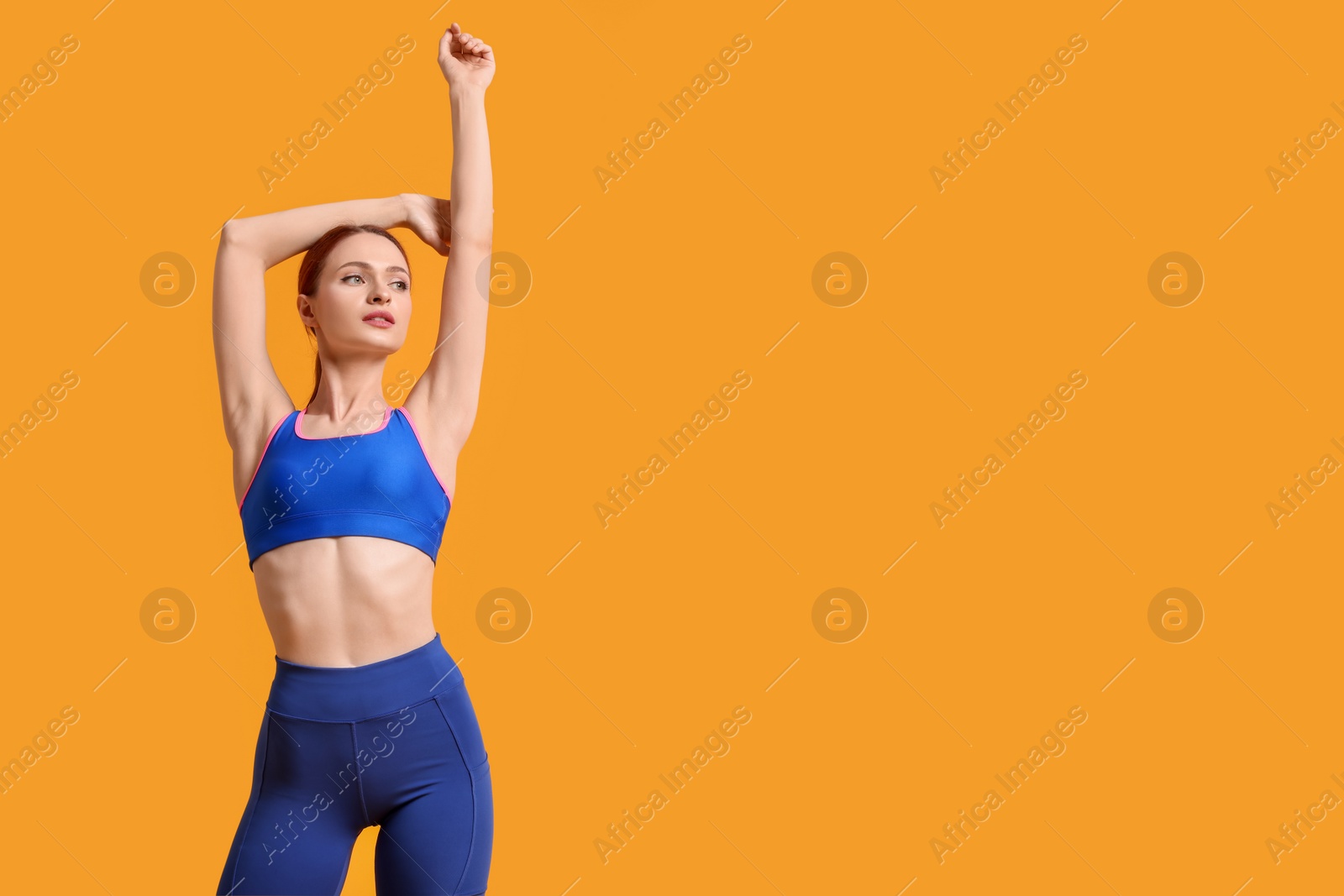 Photo of Young woman wearing sportswear on yellow background, space for text