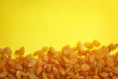 Many raisins on color background, top view with space for text. Dried fruit as healthy snack