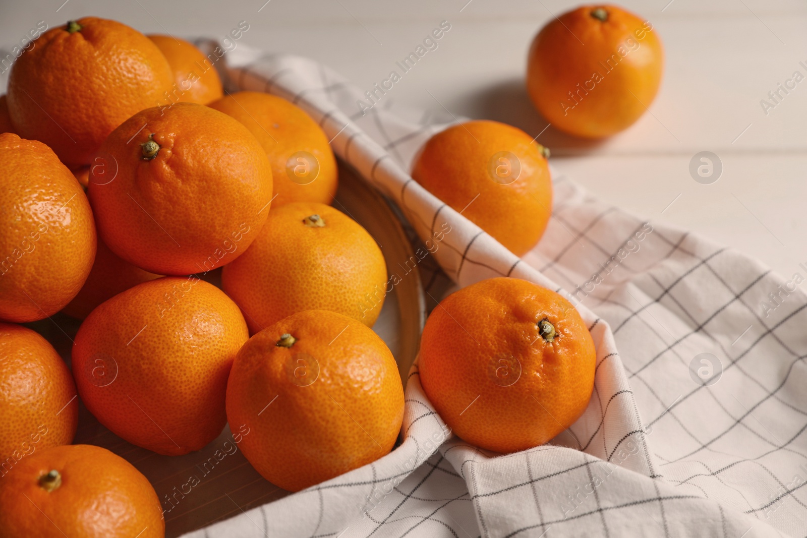 Photo of Many fresh ripe tangerines on white wooden table